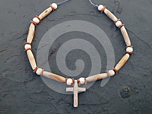 Wooden cross with a Native American designed rope for the neck.