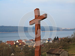 Wooden cross at pilgrimage route by lakeside village photo