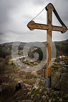 Wooden cross on the rock above the river valley