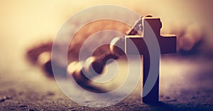 Wooden cross and rosary on stone background photo