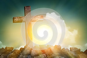 Wooden cross shape on rocky hill at sunset with blue sky