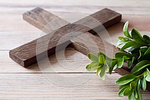 Wooden cross with sprigs of boxwood, easter symbol of life and immortality, concept photo