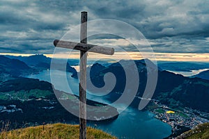 Wooden cross on summit with moody sky overlooking Lake Lucerne at Fronalpstock, Switzerland