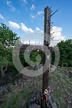 A wooden cross symbol of Christianity with a lot of driven nails in the Slovakian Little Carpathian Mountains