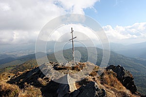 Wooden cross on top of a rocky hill
