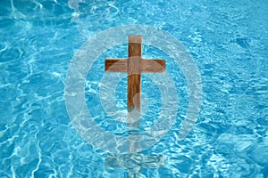 Wooden cross in water for religious ritual known as baptism