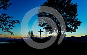 Wooden crosses sit upon a hill in the sunset with