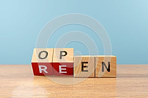 Wooden cube block flip over word REEN to OPEN on wood table, 3D render photo