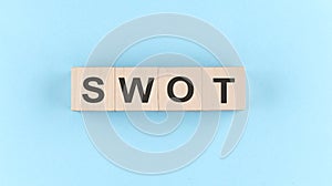 Wooden cube block with text SWOT stands for Return On Invested Capital on the blue background