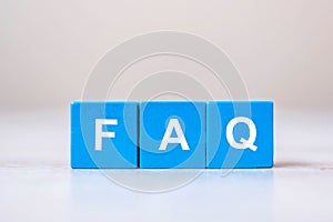 Wooden cube blocks with FAQ text  frequently asked questions on table background. Financial, marketing and business concepts