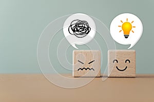 wooden cube blocks with unhappy face and happy , a tangle of thoughts and brighten lightbulb on white speech bubble, for