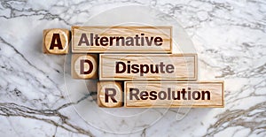 Wooden cube blocks of word text Alternative Dispute Resolution acronym ADR photo