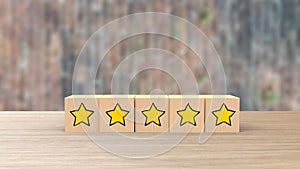 Wooden cube cartoon five yellow star review on blur wall of bricks. Service rating, satisfaction concept. reviews and comments