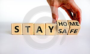 Wooden cube form the expression `stay home, stay safe`. Male hand. Beautiful white background, copy space. Medical and covid-19