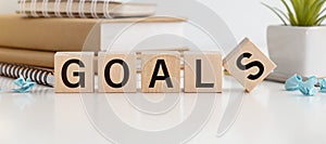 Wooden cube with Goal text on table background. Goals, success, strategy, solution concepts