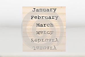 Wooden cube with the inscription January, February, March on a w