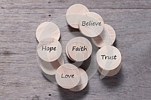 Wooden cube with inspirational text Faith, trust, believe, hope and love. Beautiful wooden table background. Business and Faith