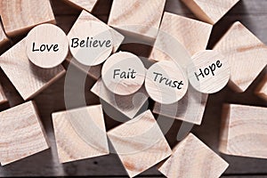 Wooden cube with inspirational text Faith, trust, believe, hope and love. Beautiful wooden table background. Business and Faith