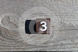 Wooden cube with the number three