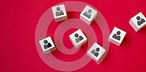 Wooden cube with person icon stand out from the crowd on red background. Dissenting opinion, divergent views and different