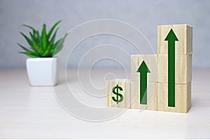 Wooden cube stack as a graph with arrows pointing up on white background. Concept of growth and success or rising successful