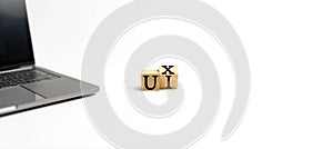 Wooden cube on a white table with text UX, UI. Concept of development and design and development, user interface, user experience