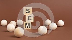 wooden cubes block with alphabet combine abbreviation SCM. SCM - short for Supply Chain Management