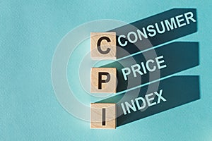 Wooden cubes building word CPI - abbreviation Consumer Price Index on light blue background