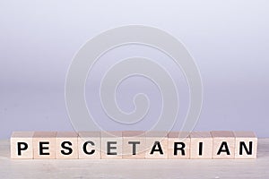 wooden cubes building the word Pescetarian, white background