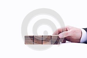 Wooden cubes. A businessman's hand flips a cube. One digit replaces another. On a white background