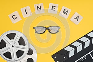 Wooden cubes with cinema lettering, clapperboard, film reels and stereoscopic 3d glasses isolated