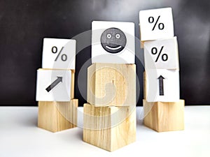 Wooden cubes in a column and a row with white signs with a smiley sign, an arrow, a percentage. The concept of