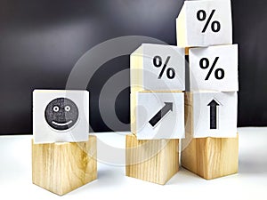 Wooden cubes in a column and a row with white signs with a smiley sign, an arrow, a percentage. The concept of