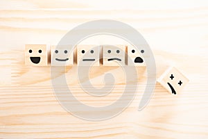 Wooden cubes that Express different emotions. smile face icon symbol on wooden cube on wooden background. concept of different