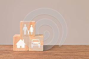 Wooden cubes with family, car and home icons. Insurance coverage concept