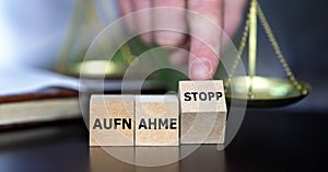 Wooden cubes form the German expression 'Aufnahme stopp' (migration stop).