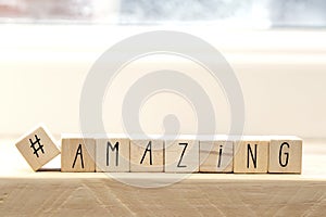 Wooden cubes with a hashtag and the word amazing, social media concept