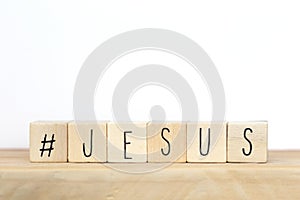 Wooden cubes with a hashtag and the word Jesus, social media concept God is love concept text background