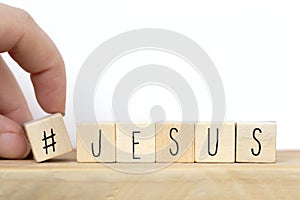 Wooden cubes with a hashtag and the word Jesus, social media concept God is love concept text background