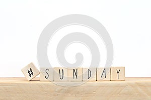 Wooden cubes with a hashtag and the word Sunday, social media concept near white background