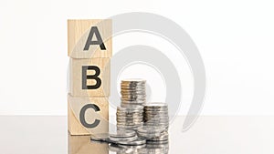 wooden cubes with the letters ABC and coins on top. business. finance