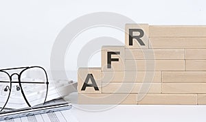 Wooden cubes with letters AFR on the white table with keyboard and glasses photo