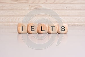 wooden cubes with letters form the expression IELTS. education concept