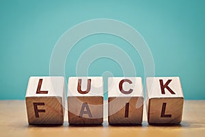 Wooden cubes with letters forming the words `luck` and `fail` with copy space: concept of strategy and attitude towards succes