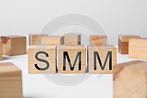 Wooden cubes with letters SMM on white table