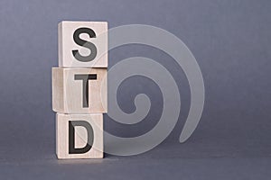 Wooden cubes with letters STD on violet background