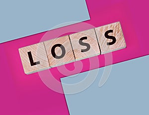 Wooden cubes with LOSS word on pink magenta. Financial loss business concept