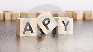 wooden cubes with text APY on gray table