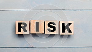 Wooden cubes with the text RISK on a light blue wooden background