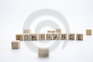 The wooden cubes with the word DOMINANCE against white background. Business, domination concept